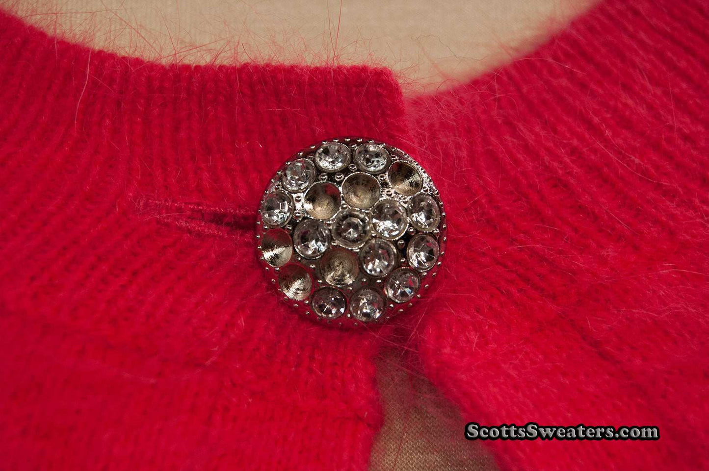 Close-up of woman's red angora shrug with jeweled rhinestone button by Express