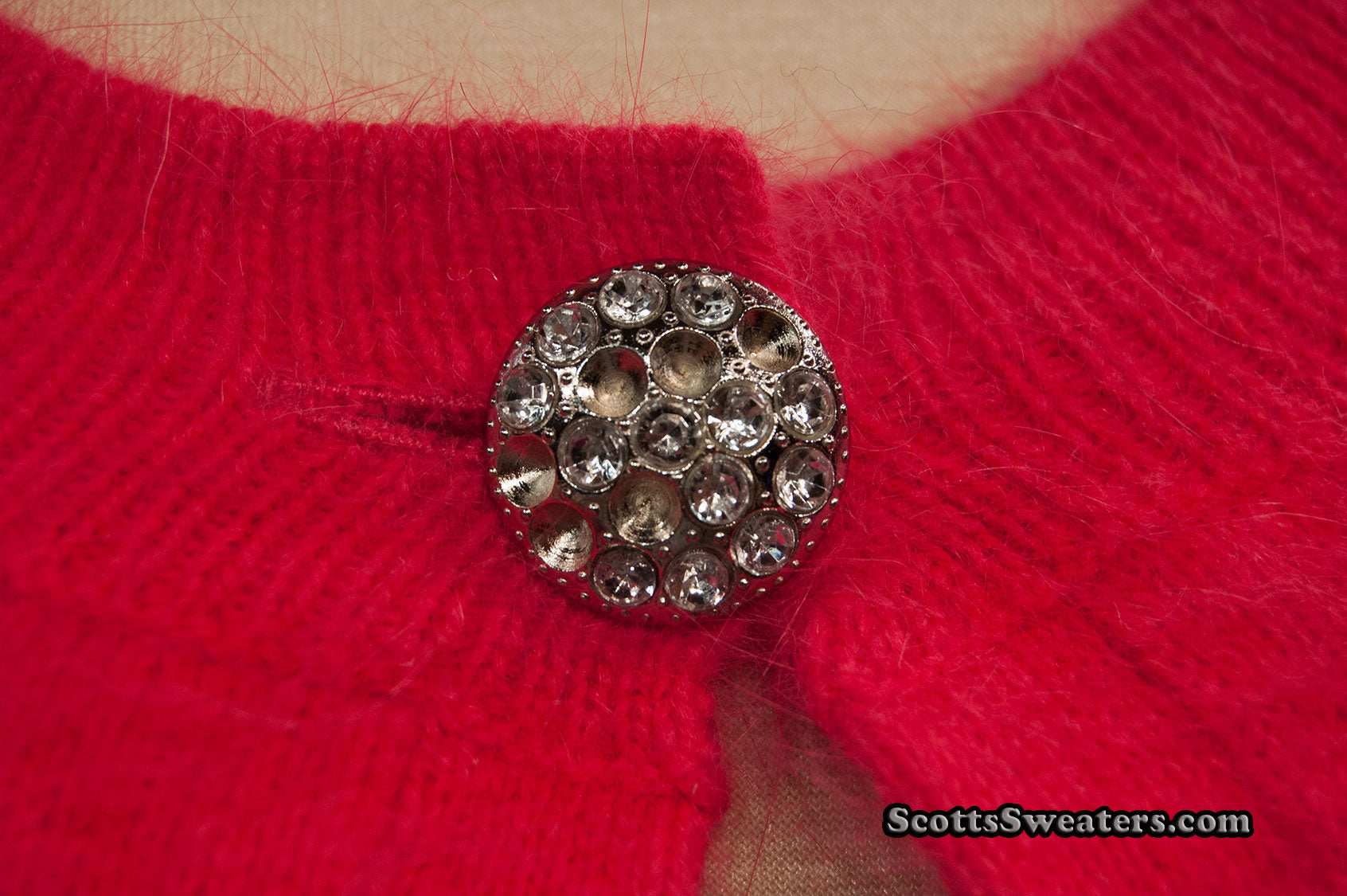 Close-up of woman's red angora shrug with jeweled rhinestone button by Express