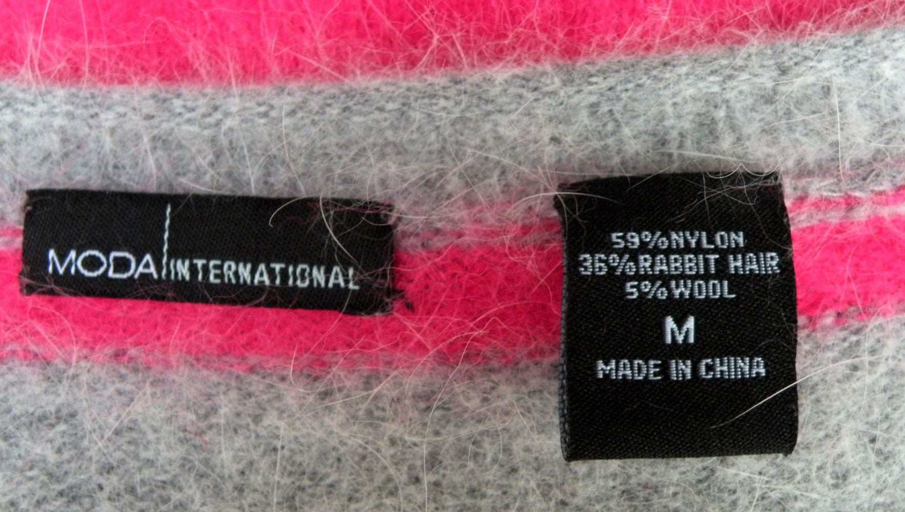 Close-up of woman's pink and grey striped angora cardigan sweater label by MODA International, size medium.