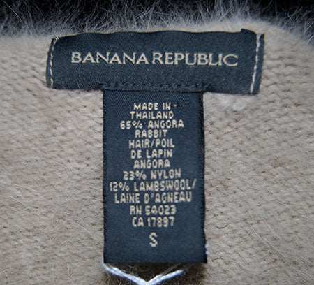 Woman wearing a muted tan Angora scoop neck sweater by Banana Republic in cling-fit design
