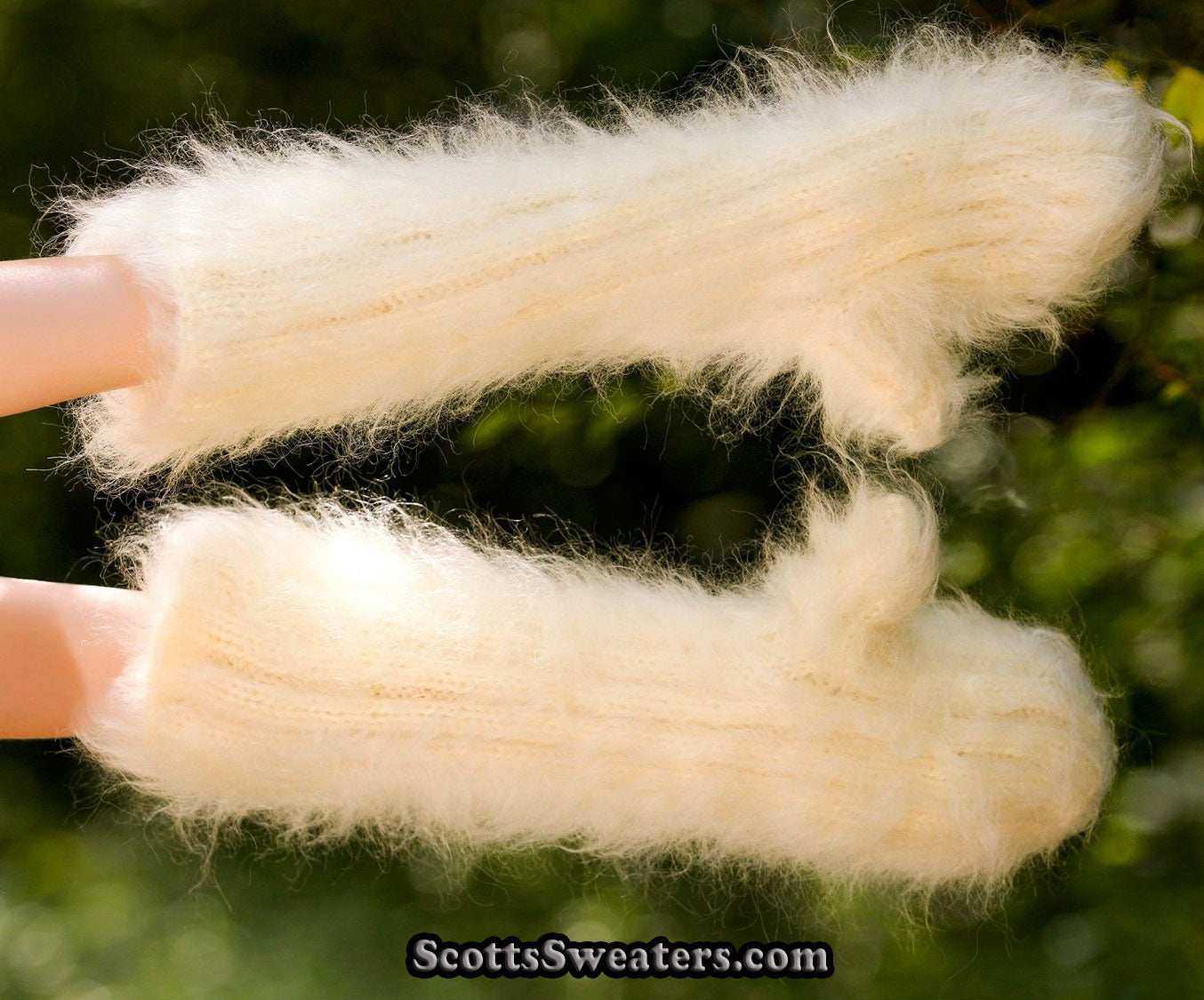 Extra-long forearm length fuzzy hand-knit mohair mittens in cream color on hands outdoors