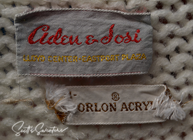 Close-up of Original Retro Classic Tennis Sweater label showing Aden & Dosi brand and Orlon acrylic material on white knit fabric