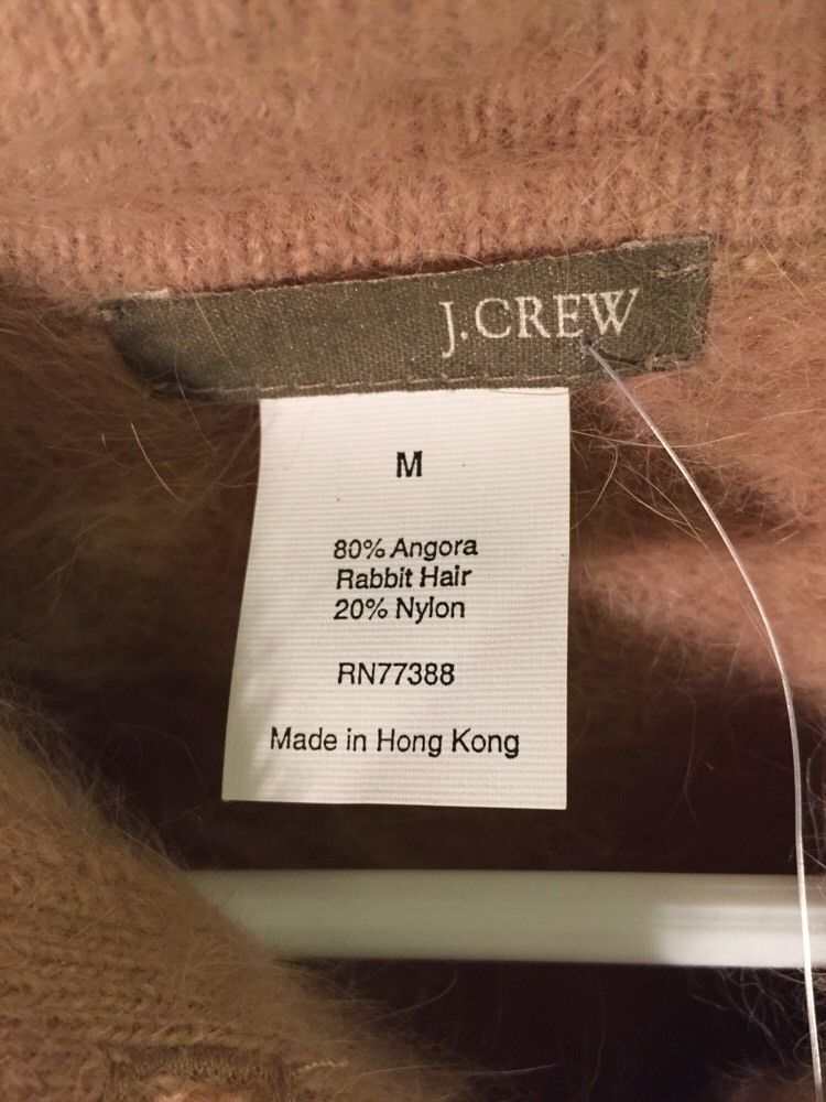 Beige woman's short-sleeve polo-neck angora sweater label by J.Crew showing size and material details