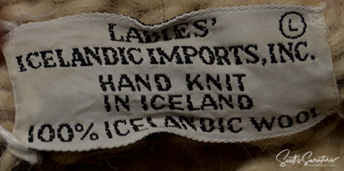 Label of woman's Icelandic wool cardigan sweater showing hand-knit in Iceland and 100% Icelandic wool details