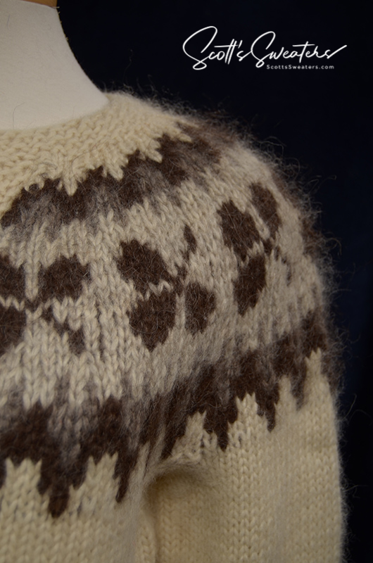 Close-up of woman's Icelandic wool cardigan sweater in natural brown tones with traditional pattern and metal buttons