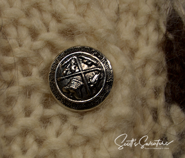 Close-up of metal button on natural wool color Icelandic wool cardigan sweater for women
