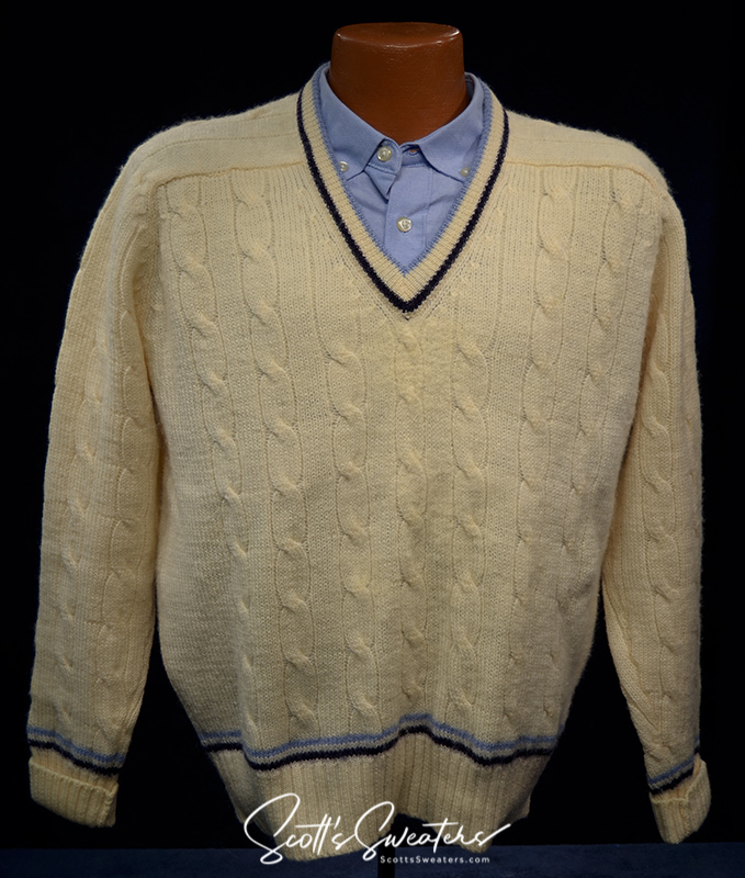 Retro classic ivory wool cable-knit tennis sweater with navy and French blue striped trim on V-neck, cuffs, and waist.