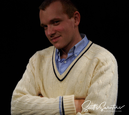 Man wearing Retro Classic Ivory Wool cable-knit tennis sweater with navy and French blue striped trim over blue shirt