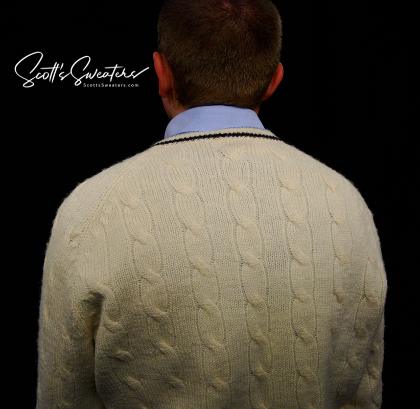 Retro classic ivory wool cable-knit tennis sweater with navy and French blue striped trim on neck, cuffs, and waist.