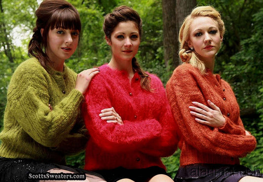 Three women wearing retro Italian mohair cardigans in green, red, and orange cable-knit styles outdoors.