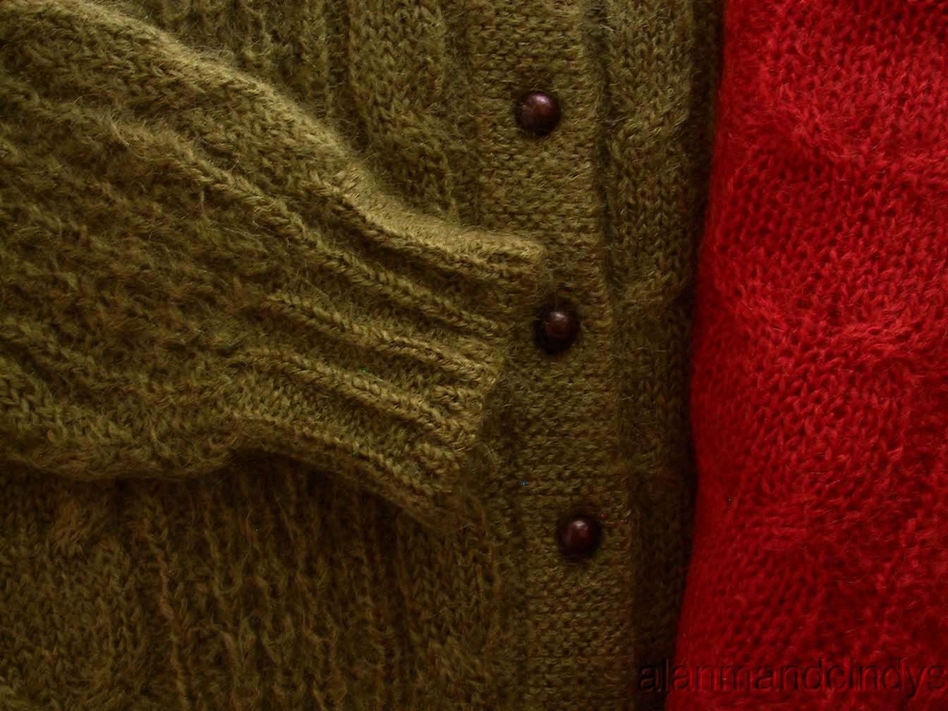 Close-up of woman's retro Italian mohair cable-knit cardigan sweaters in olive green and red with buttons