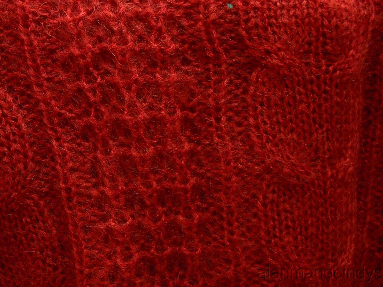Close-up of red cable-knit mohair fabric from woman's retro Italian cardigan sweater