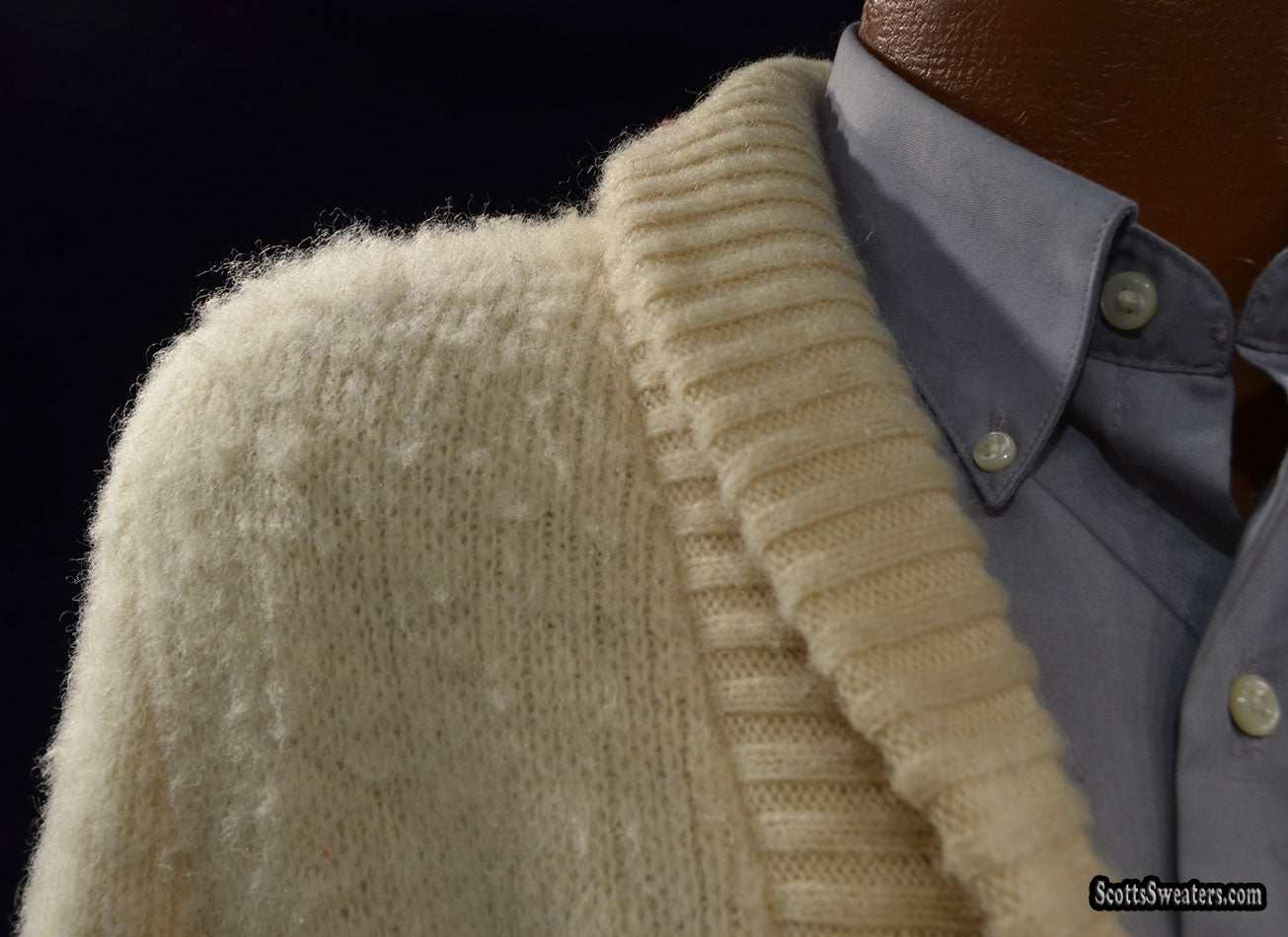 Close-up of a cream-colored woman's Icelandic wool sweater wrap with a ribbed shawl collar over a buttoned shirt