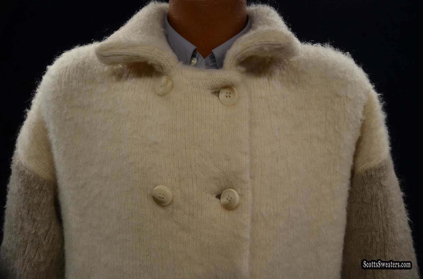 Ivory and tan double-breasted woman's Icelandic wool pea coat by Hilda Ltd with nylon lining displayed on a mannequin against black background