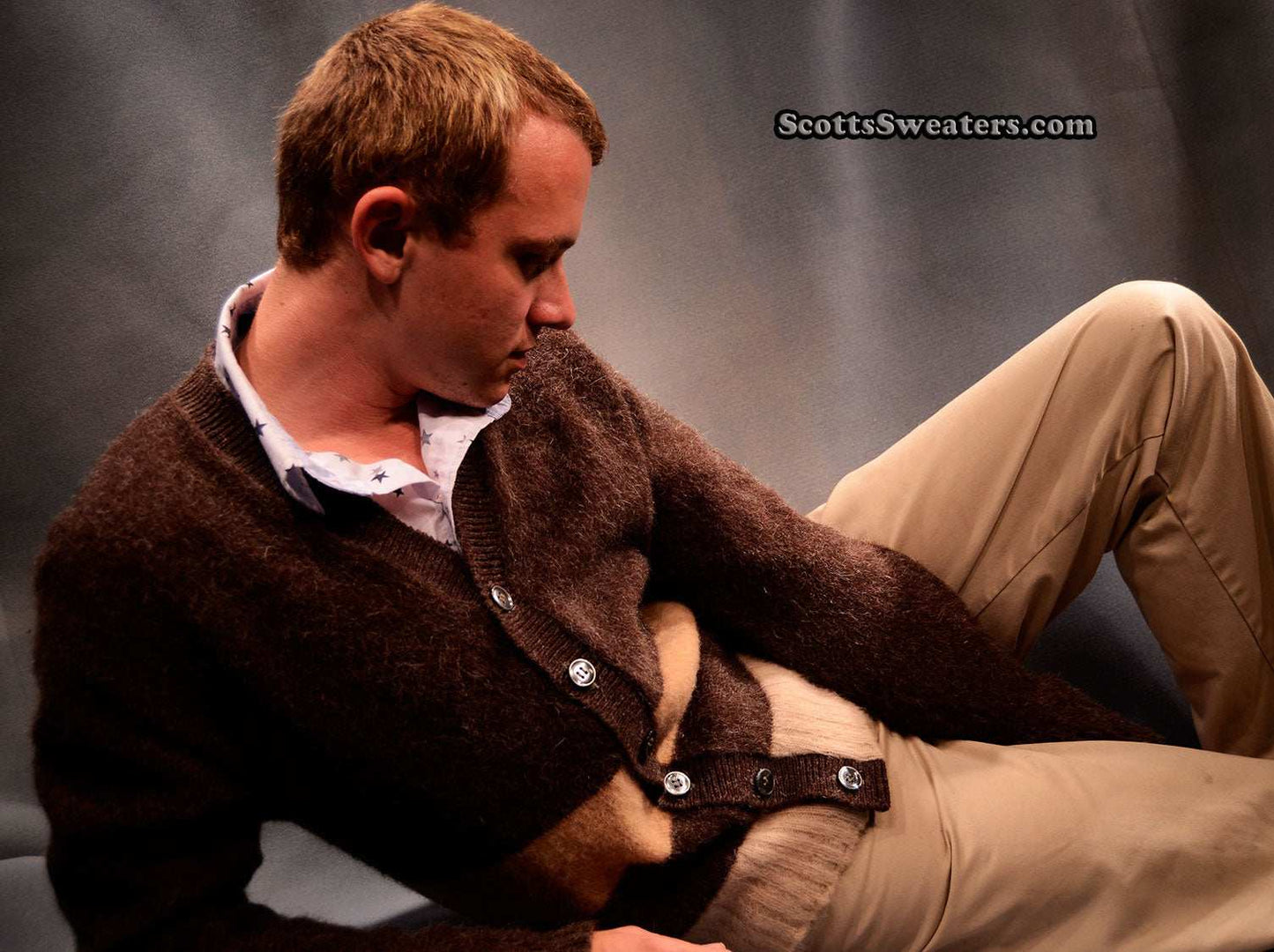 Men's retro classic two-tone brown mohair cardigan sweater modeled while reclining with beige pants