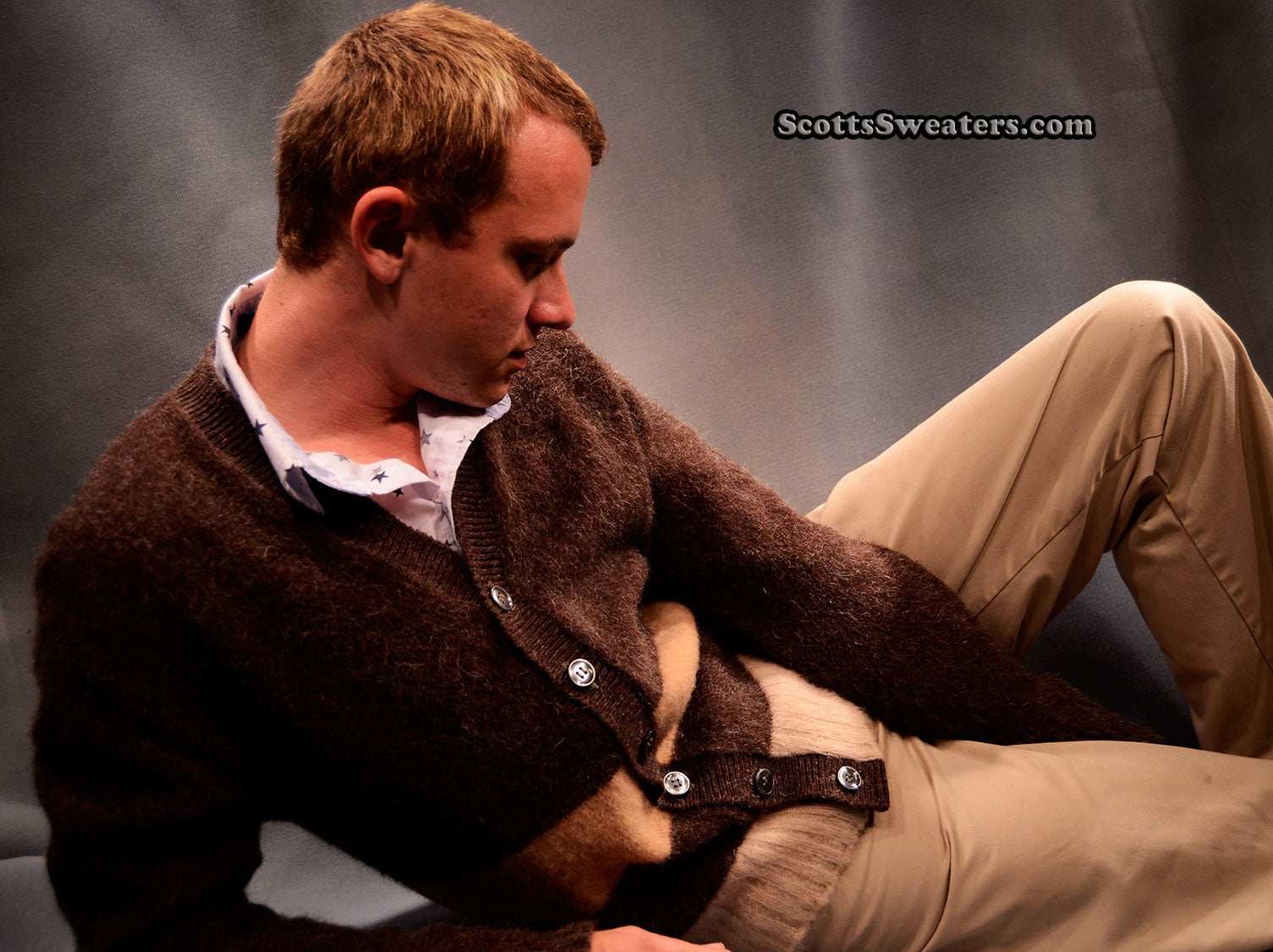 Men's retro classic two-tone brown mohair cardigan sweater modeled while reclining with beige pants