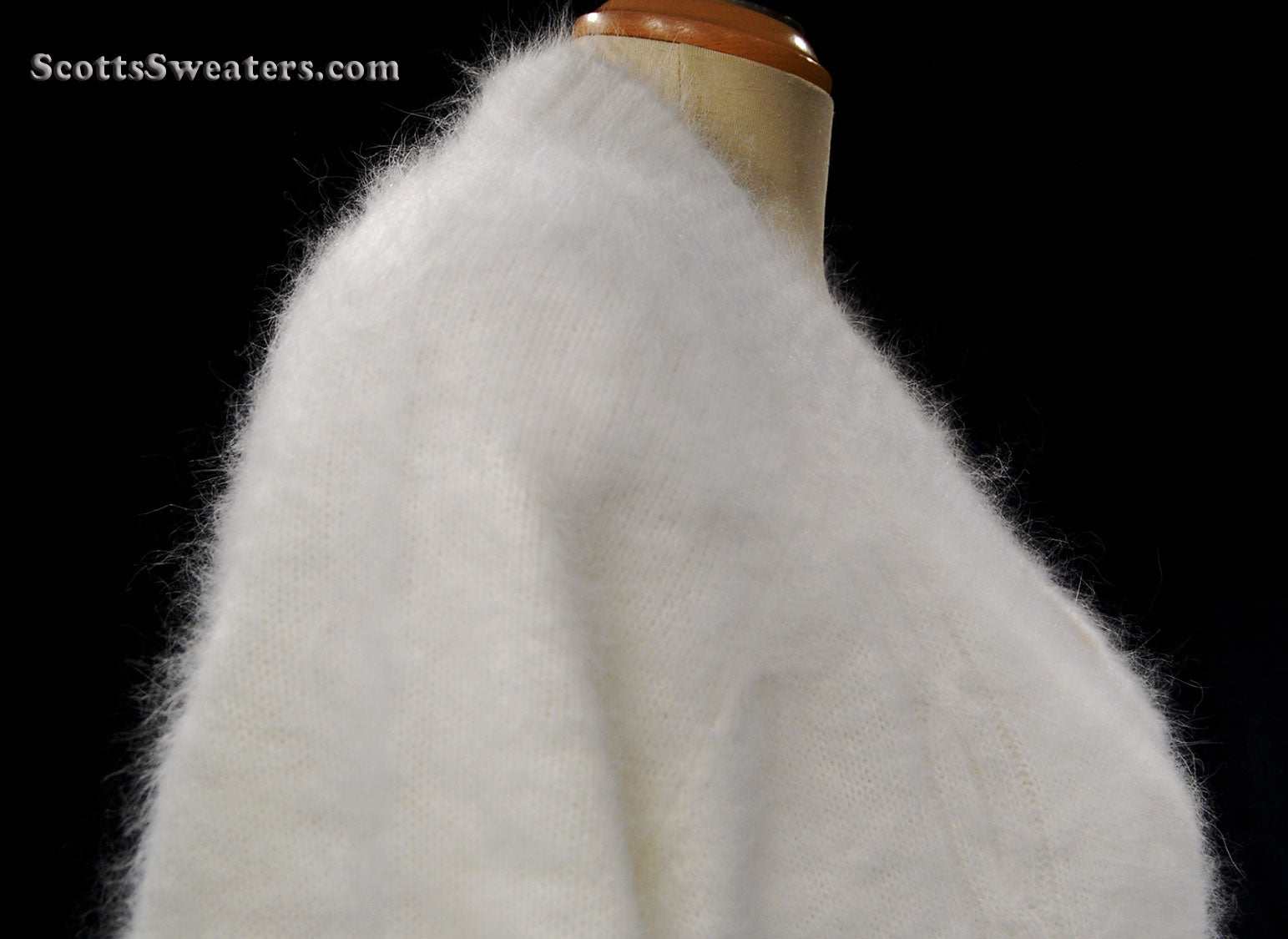 Woman's white angora shawl-neck cardigan sweater with single-button closure on mannequin
