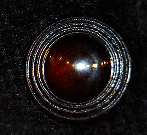 Close-up of button on woman's black angora cardigan sweater by Venesha