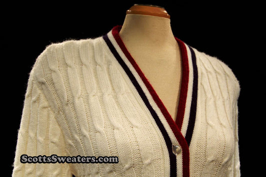 Woman's retro white cable-knit cardigan tennis sweater with red and blue trim stripes on mannequin