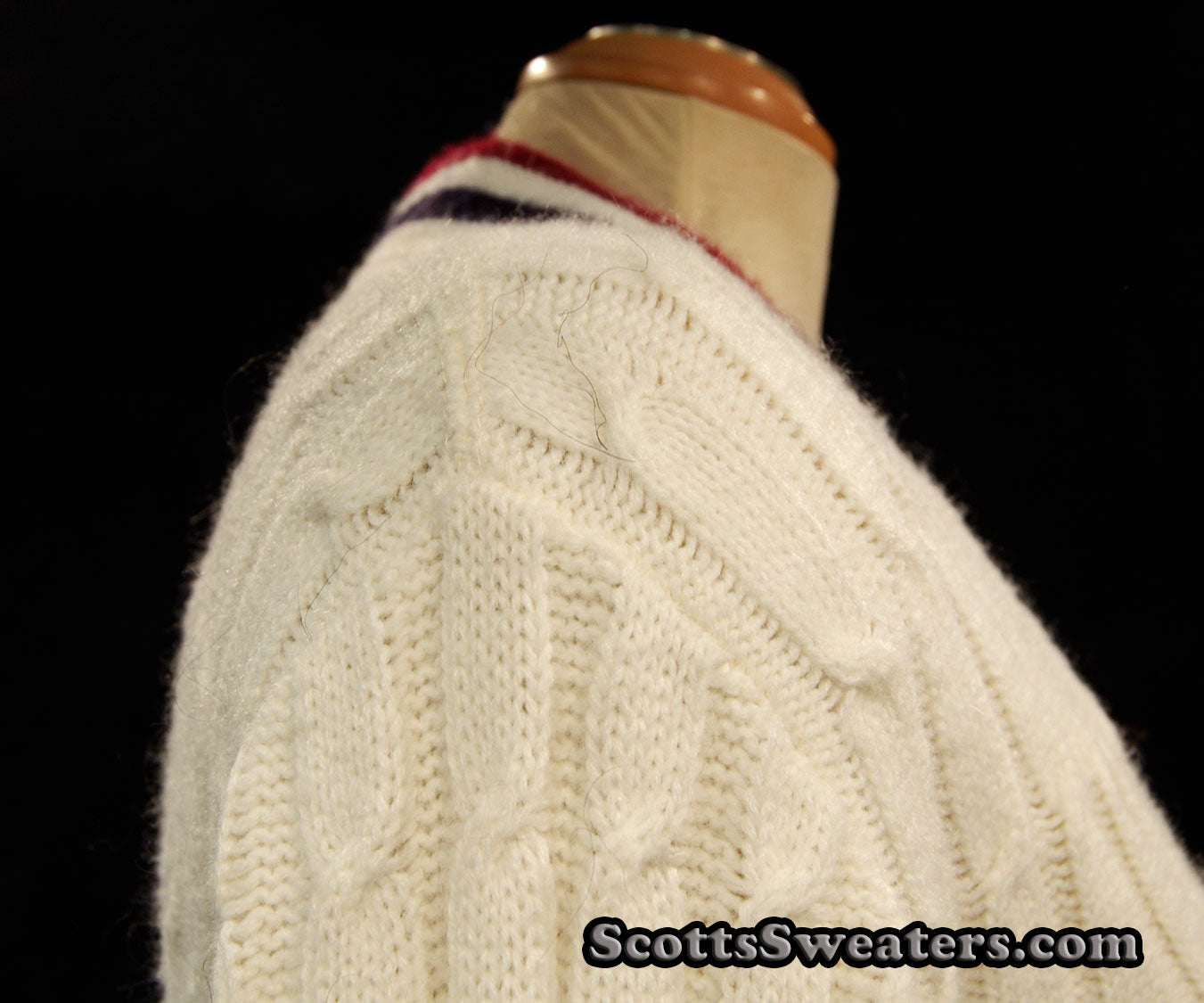 White woman's retro cardigan cable-knit sweater with red and blue trim stripes on a mannequin