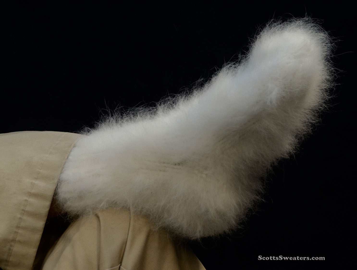 White hand-knit Siberian Angora socks, thick and warm, worn on a foot against a black background