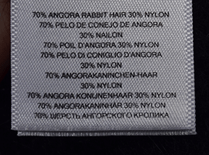 Woman's black V-neck angora sweater by Michael Kors with 70% angora rabbit hair and 30% nylon fabric tag close-up