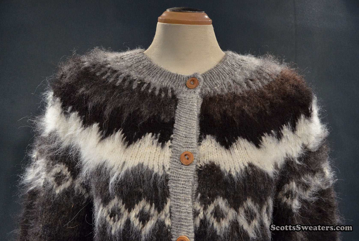 Woman's grey ultra-soft alpaca cardigan sweater with grey-white-black yoke design, wooden buttons, and fluffy texture.