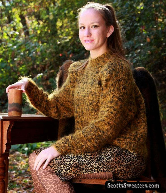 Woman wearing gold and black tweed mohair crewneck sweater seated outdoors with a cup in hand