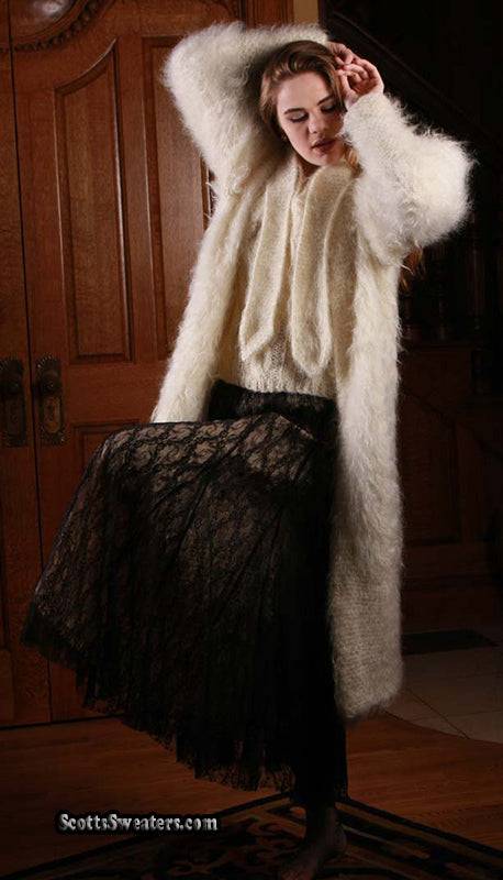 Woman wearing an ivory full-length mohair sweater-coat by Arundell paired with a black lace skirt