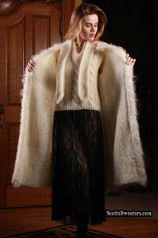 Woman wearing ivory full-length mohair sweater-coat by Arundell UK with black skirt indoors
