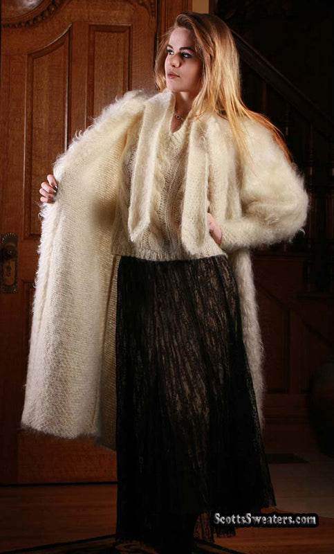 Woman wearing ivory full-length mohair sweater-coat by Arundell UK with black skirt indoors