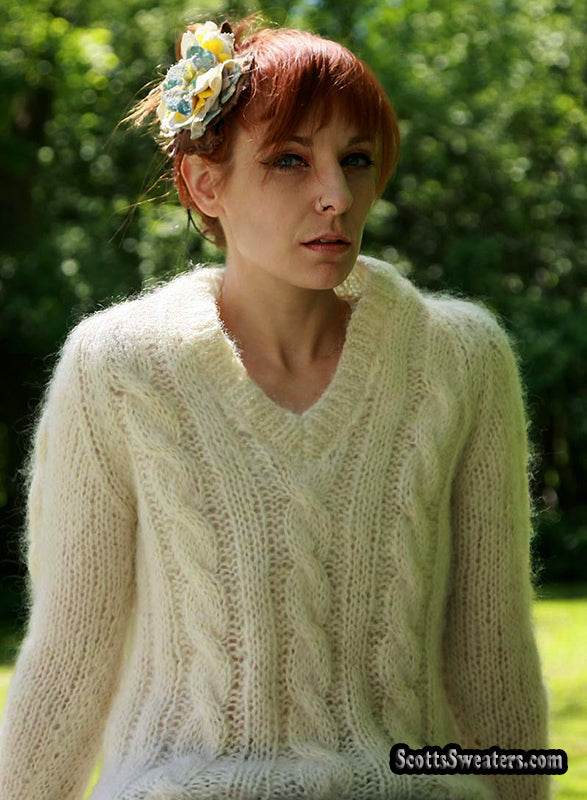 Woman's ivory cable-knit V-neck mohair-wool sweater by Tam Italia worn outdoors