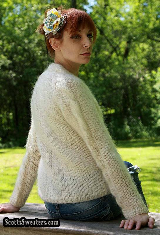 Woman's ivory cable-knit V-neck mohair sweater worn outdoors