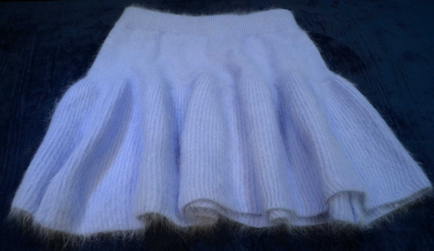 Soft light purple woman's short angora skirt with elastic waistband on dark background