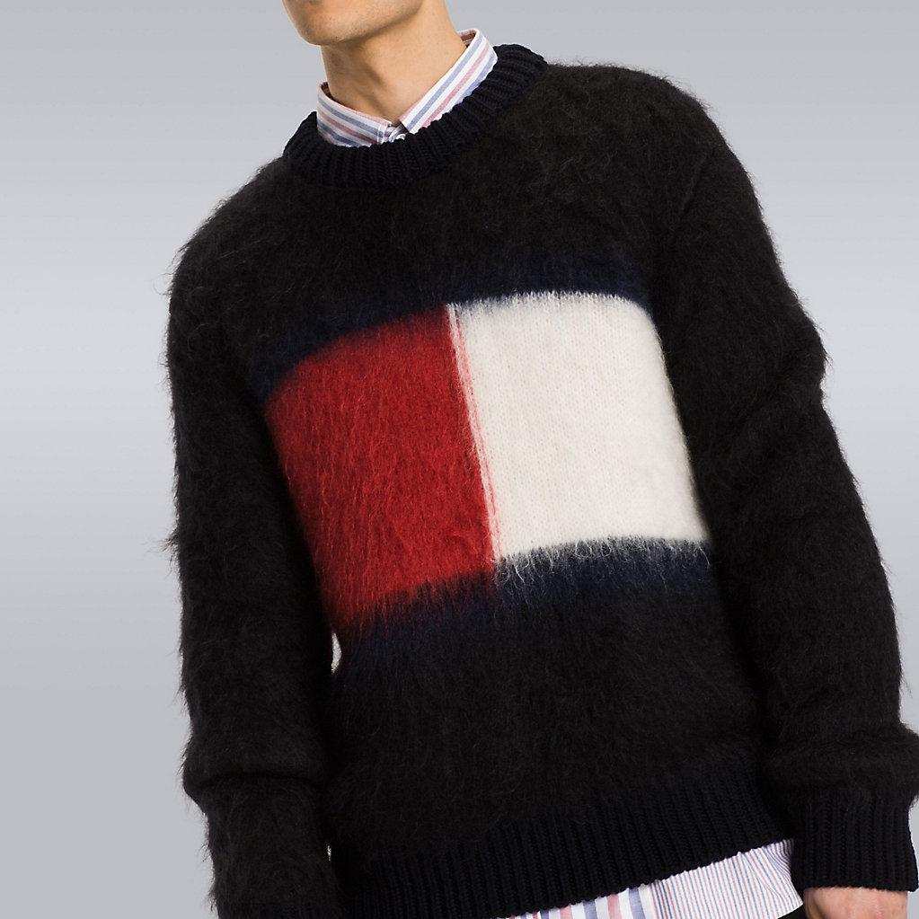 Men's black Tommy Hilfiger mohair crewneck sweater with large red, white, and navy flag logo on chest