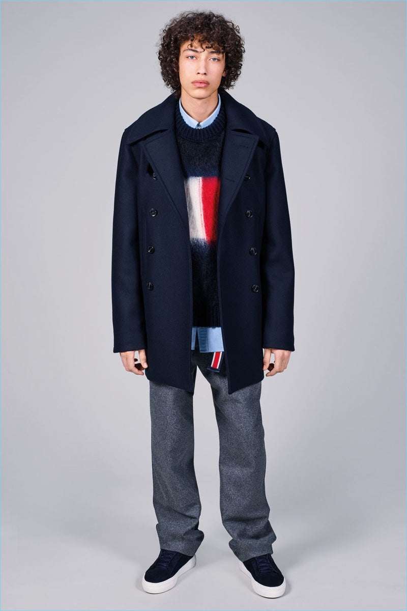 Men's black crewneck Tommy Hilfiger mohair sweater with large flag logo on chest, styled with navy coat and gray pants