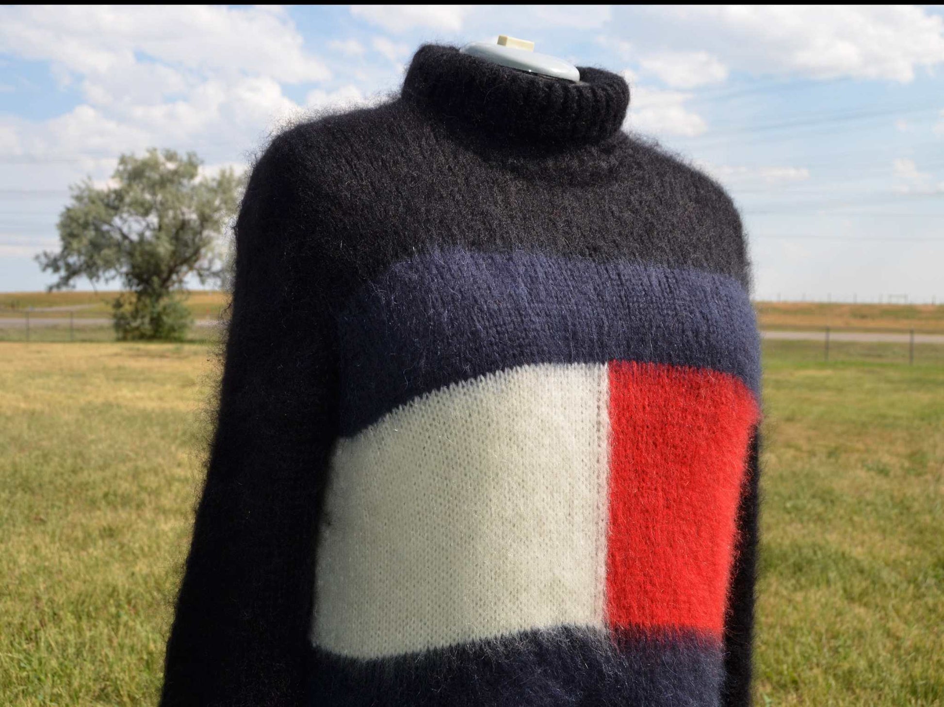 Woman's fuzzy mohair sweaterdress with turtleneck and Tommy Hilfiger logo in black, navy, white, and red colors outdoors