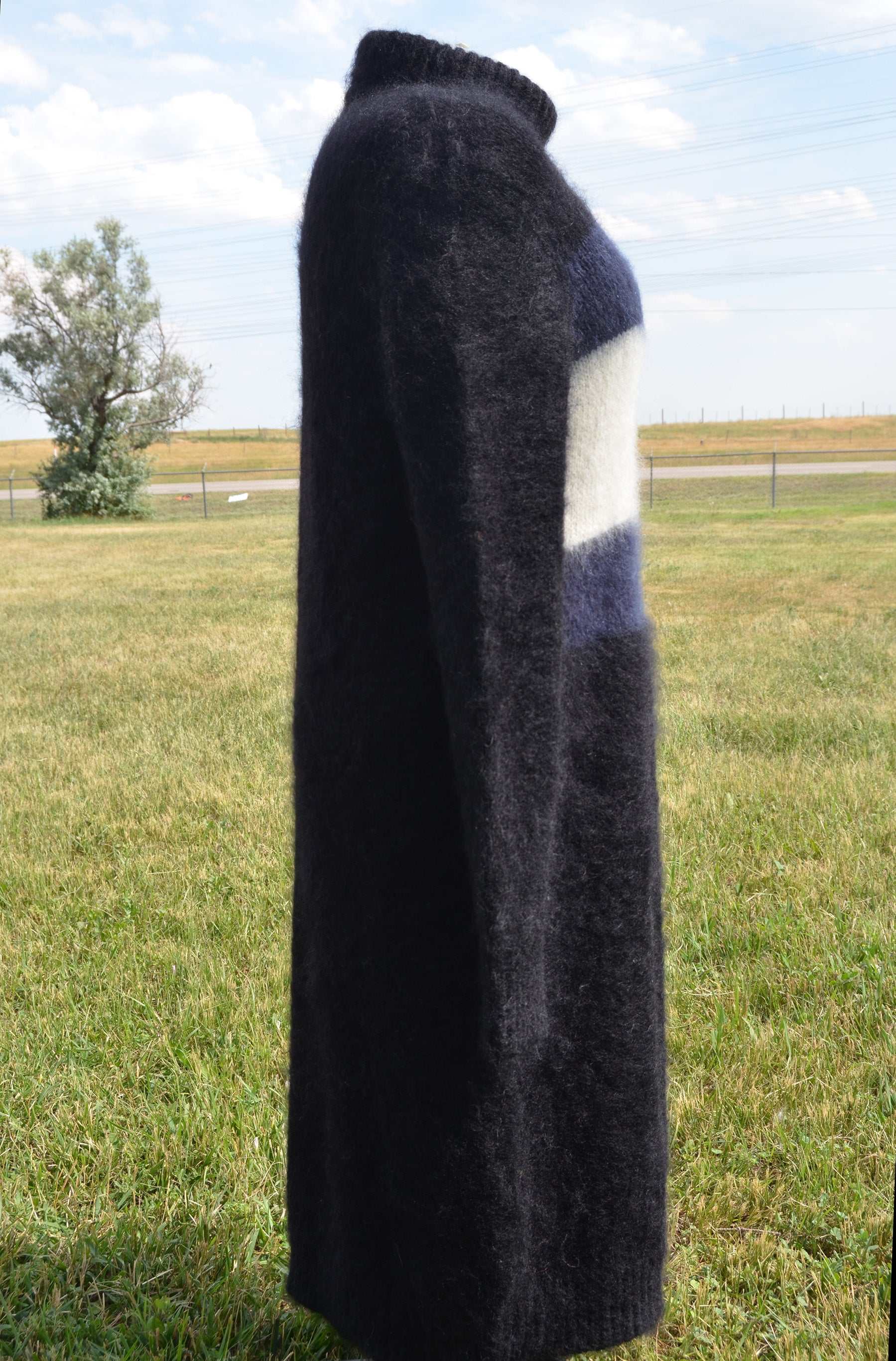 Black fuzzy mohair turtleneck sweaterdress with Hilfiger logo by Tommy Hilfiger displayed outdoors