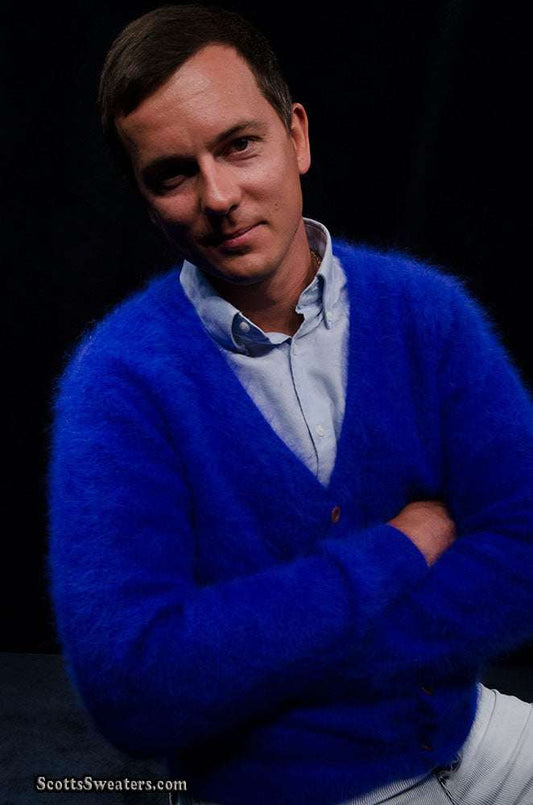 Men's ultra-soft angora cardigan sweater in vibrant blue worn by a man against black background