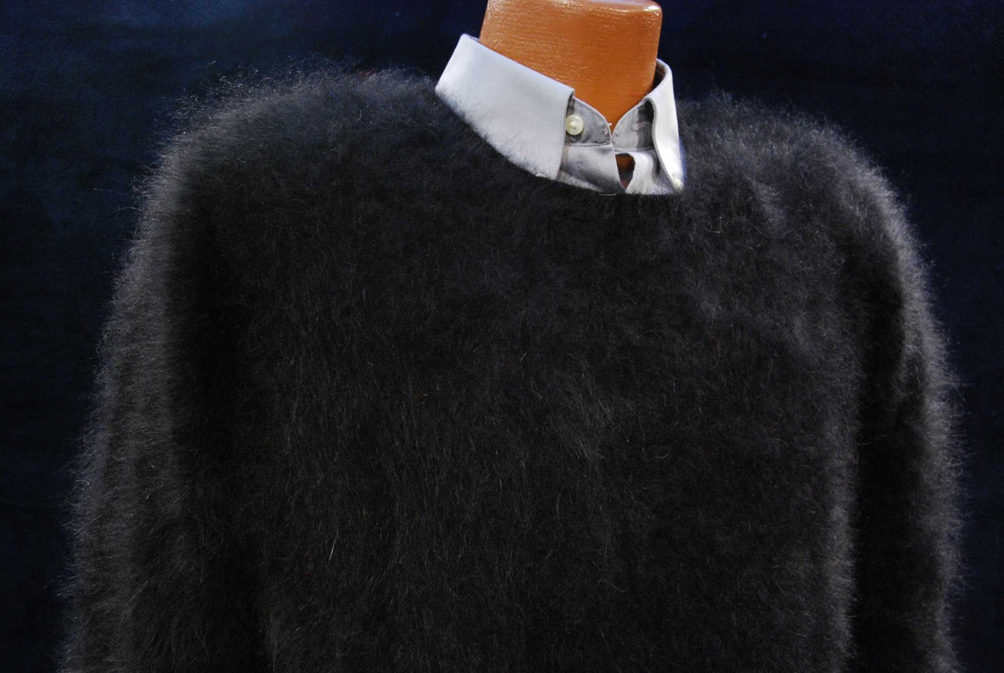 Men's ultra-soft black angora crewneck sweater on mannequin with light blue collared shirt