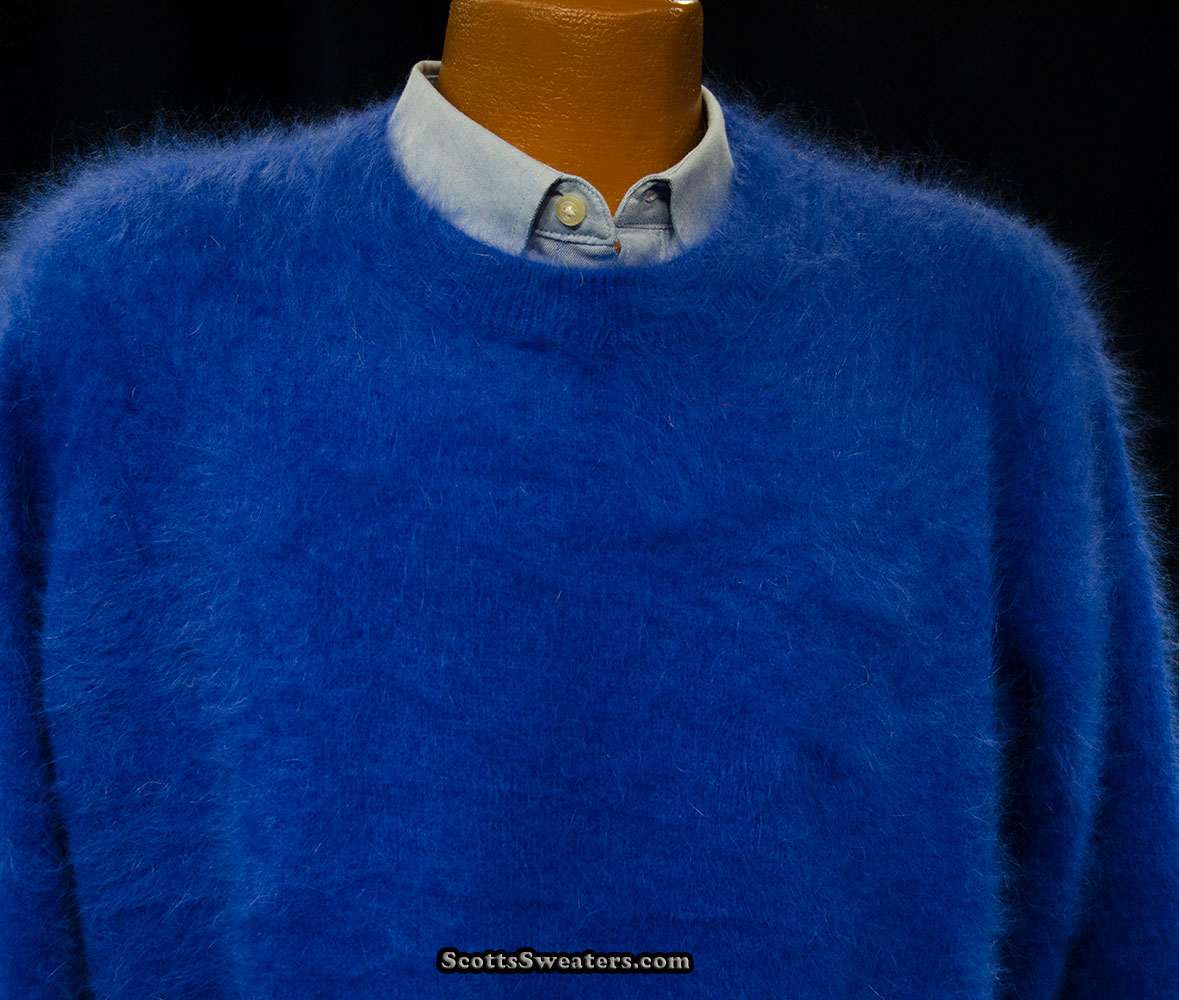 Men's ultra-soft blue angora crewneck sweater layered over a light blue button-up shirt on a mannequin