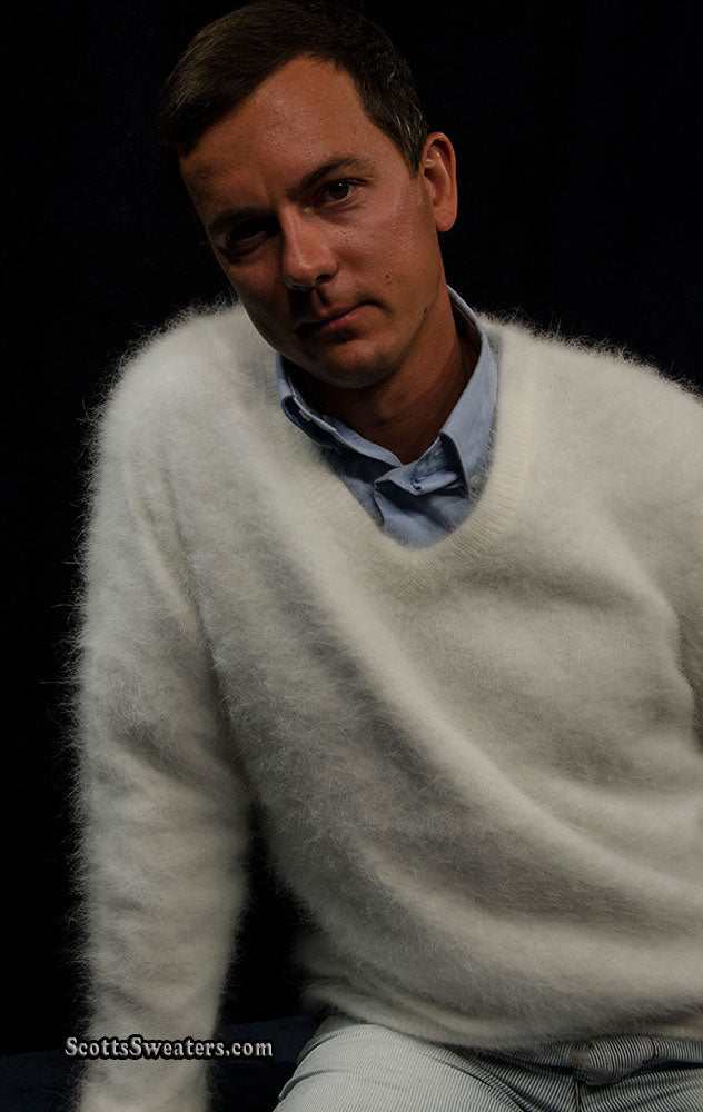 Man wearing a white men's ultra-soft angora V-neck sweater against a dark background