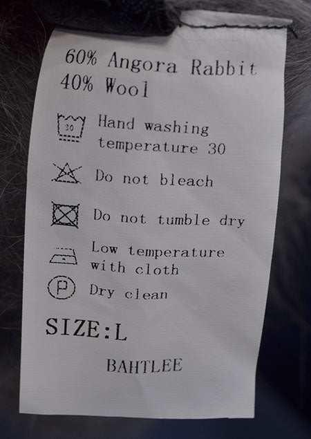Care label for woman's super-soft grey and white argyle angora sweater with 60% angora rabbit and 40% wool blend, size large, with washing instructions.