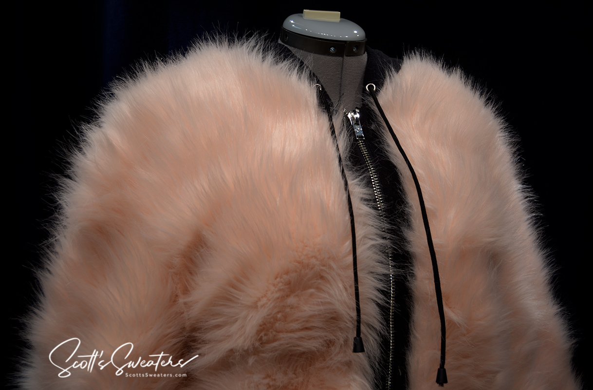 Punk style thick fluffy faux-fur jacket with zipper front and hanging straps on cuffs