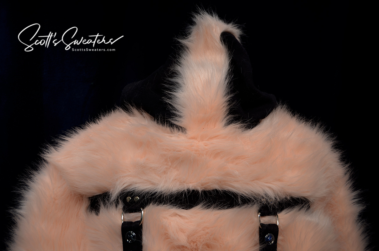 Punk style thick and fluffy faux-fur pink jacket with black hood, hanging straps, and metal D-rings on cuffs