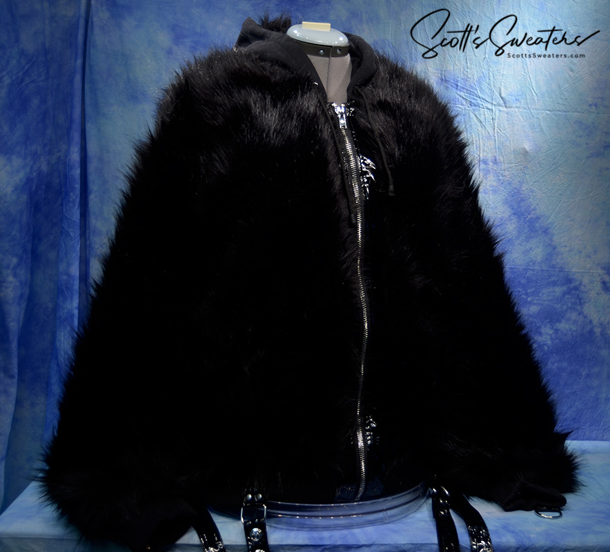 Punk style thick fluffy black faux-fur jacket with zipper, hood, hanging straps, and metal D-rings on cuffs