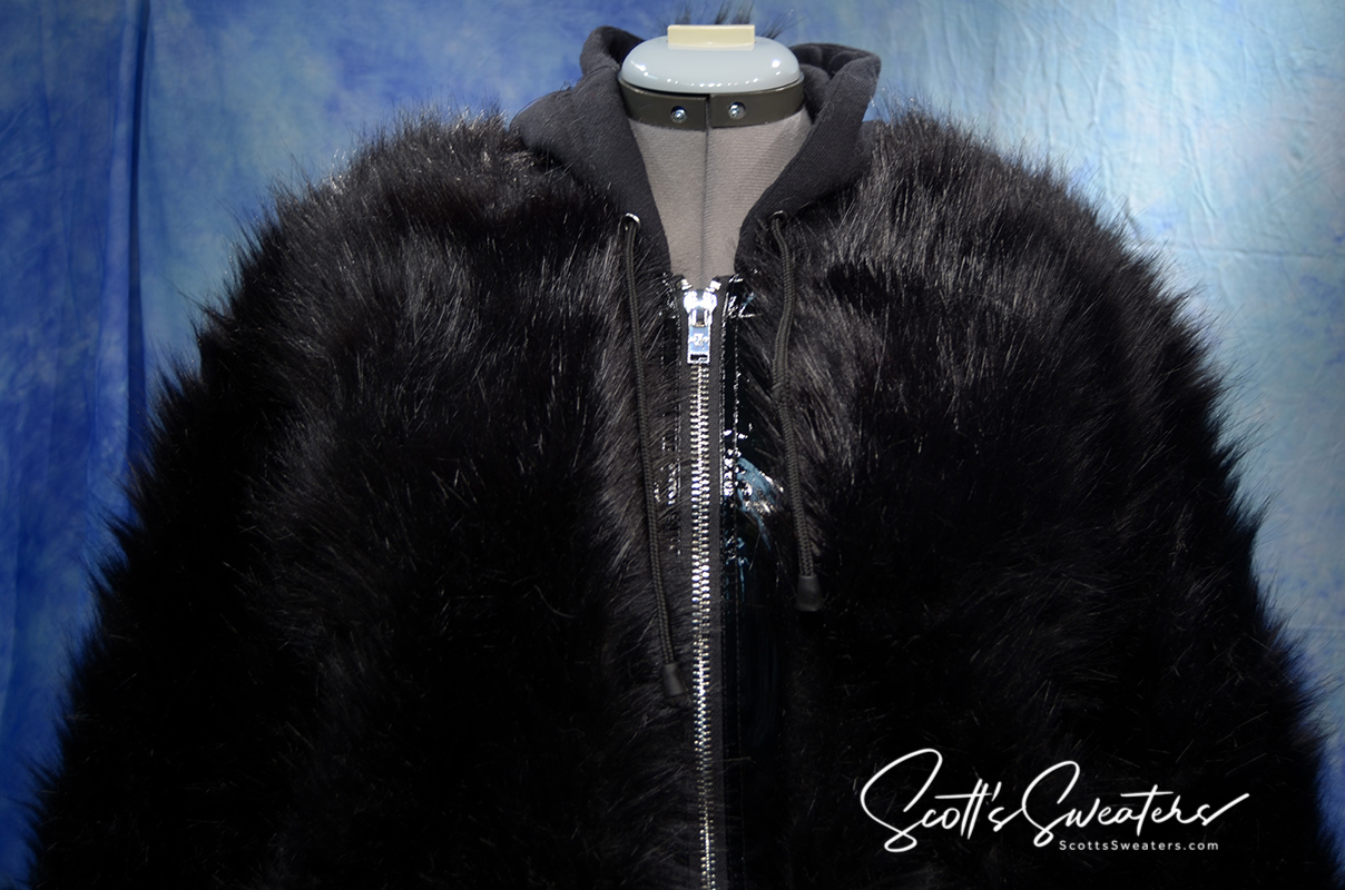 Punk style thick and fluffy black faux-fur jacket with zipper front and hood on mannequin