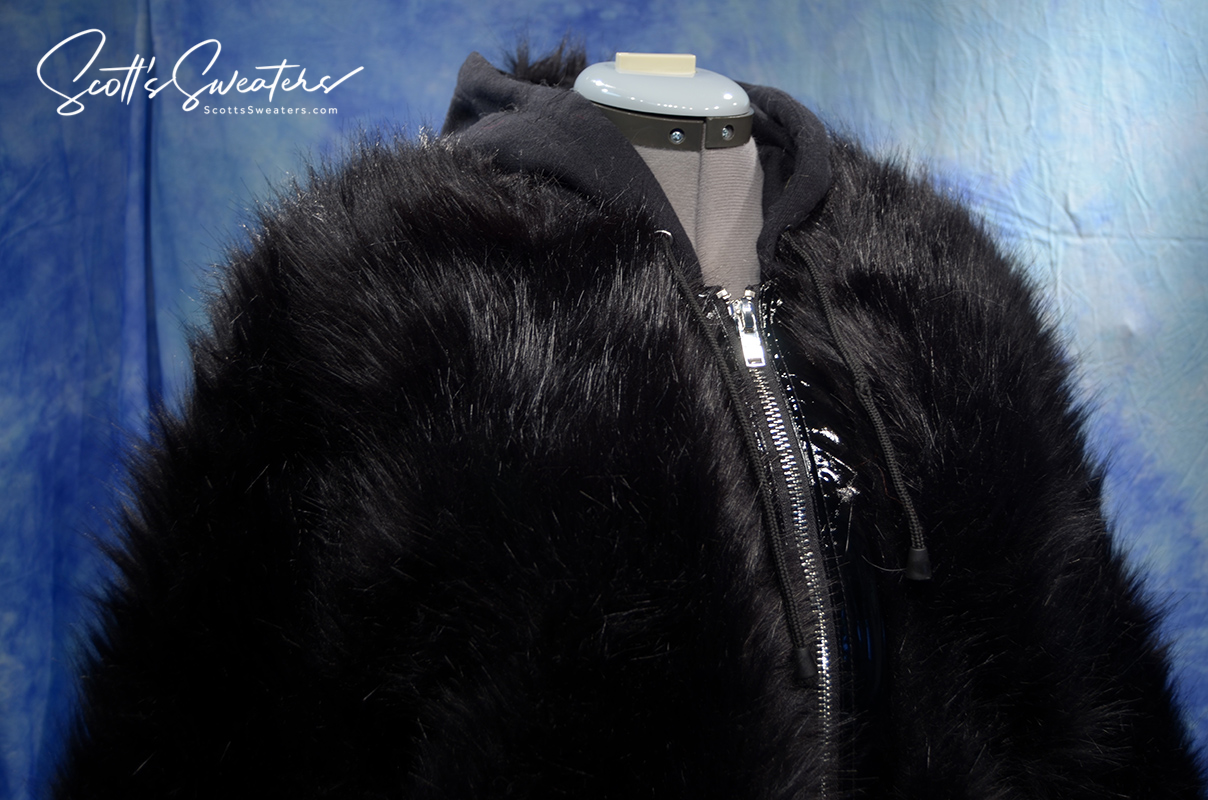 Punk style thick and fluffy black faux-fur jacket with zipper front, hood featuring Mohawk design, hanging straps, and metal D-ring cuffs.