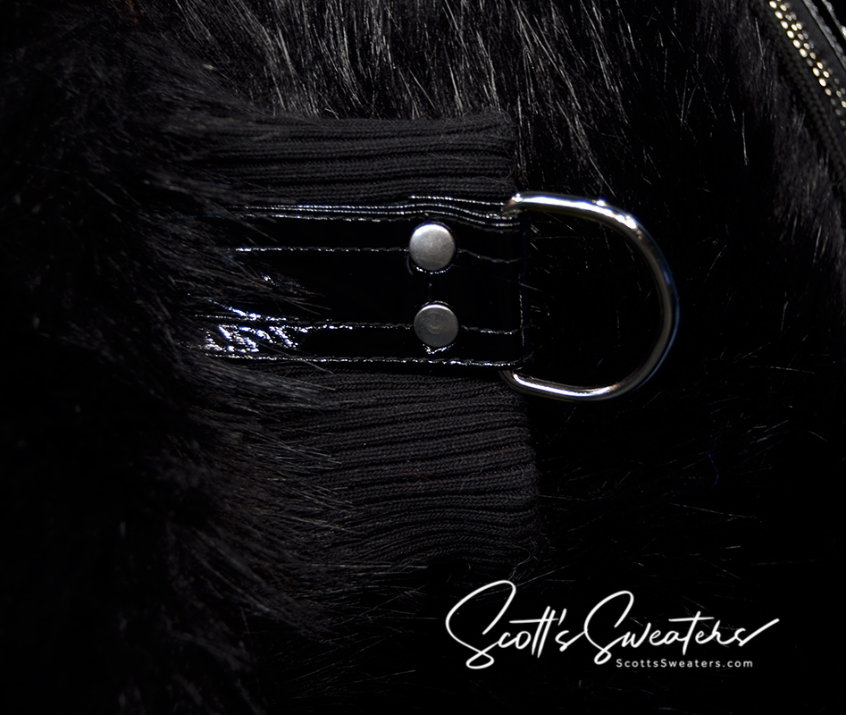 Close-up of black faux-fur punk style thick jacket cuff with metal D-ring and hanging strap detail