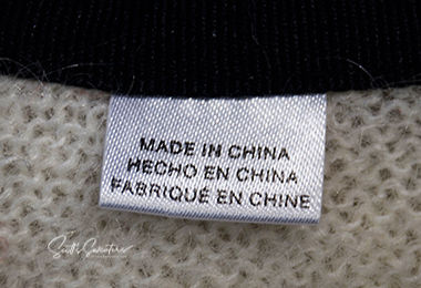 Close-up of clothing label stating "Made in China" on WeSC skateboarder street wear mohair cardigan sweater